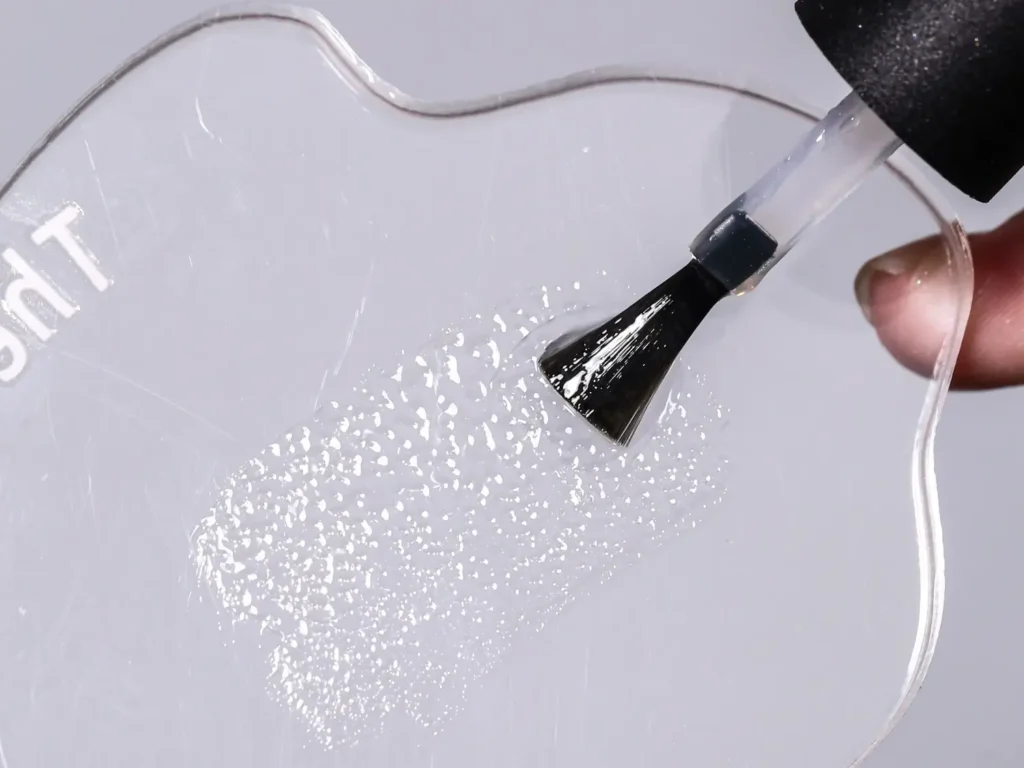 Close-up view of clear non-wipe gel fluid spreading on a transparent palette showcasing self-patterning 3D water ripple ridges