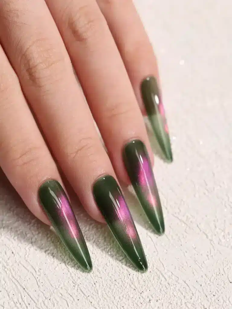 Long professional stiletto extensions with a smooth self-leveled green and pink cat eye layout showing zero brush marks or streaks