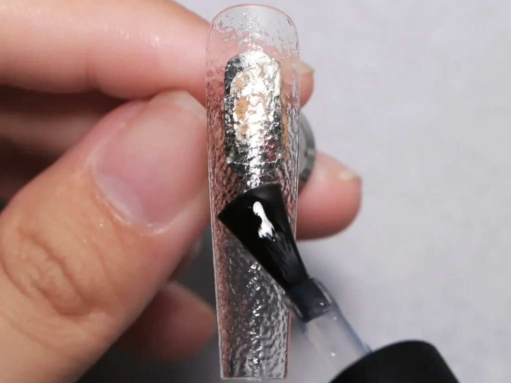 Macro shot of JTING high-viscosity clear gel being brushed onto a long stiletto nail tip to demonstrate thixotropic architectural build