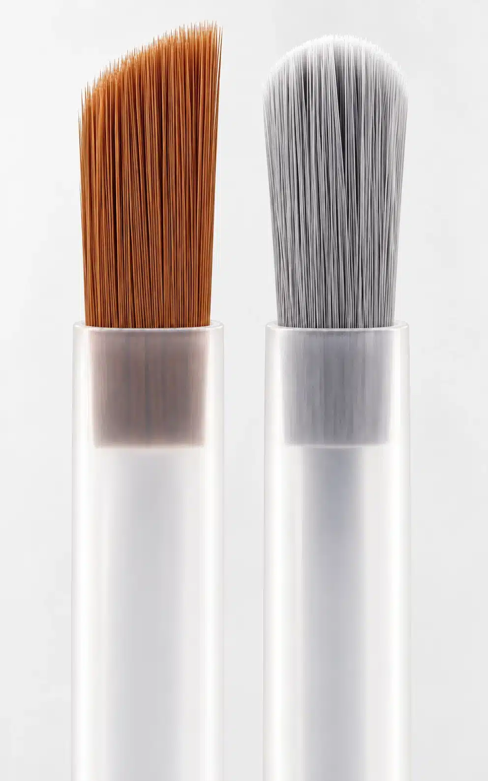 Brown angled and gray rounded brush heads with extended translucent plastic stems.