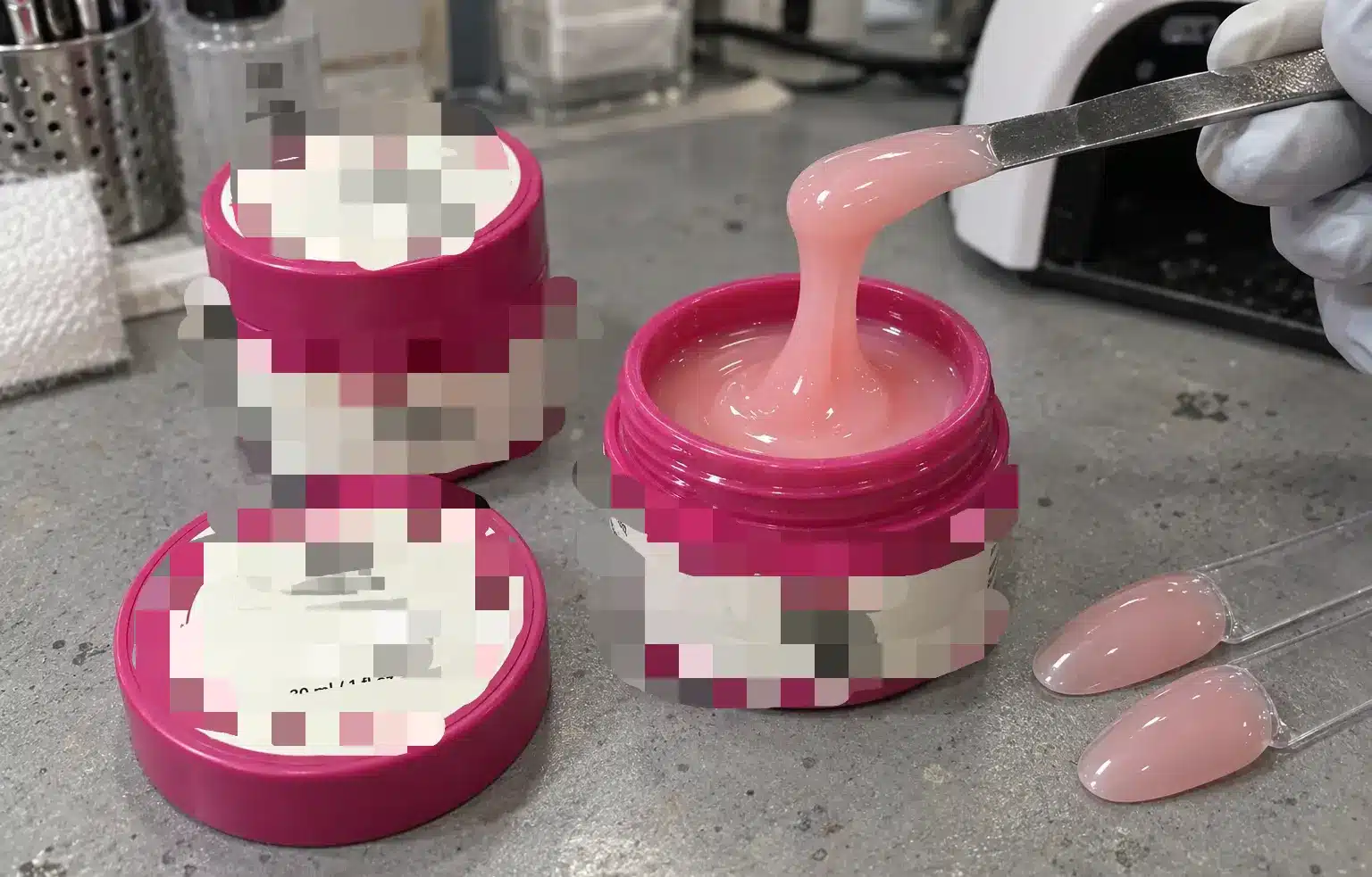 Pink builder gel sample testing with floral-label jars and nail swatches.