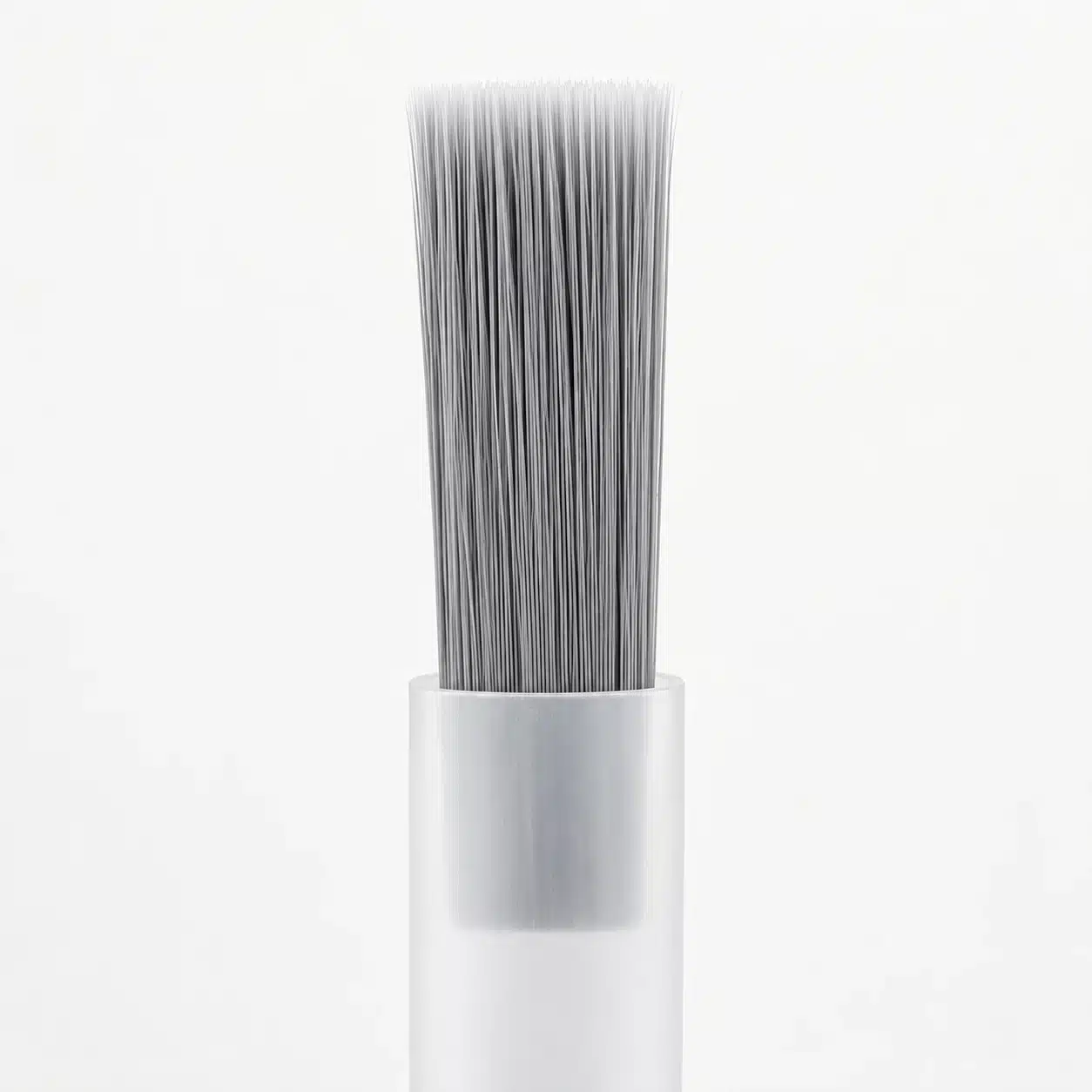 Gray bottle brush with a straight bristle edge and translucent plastic stem.