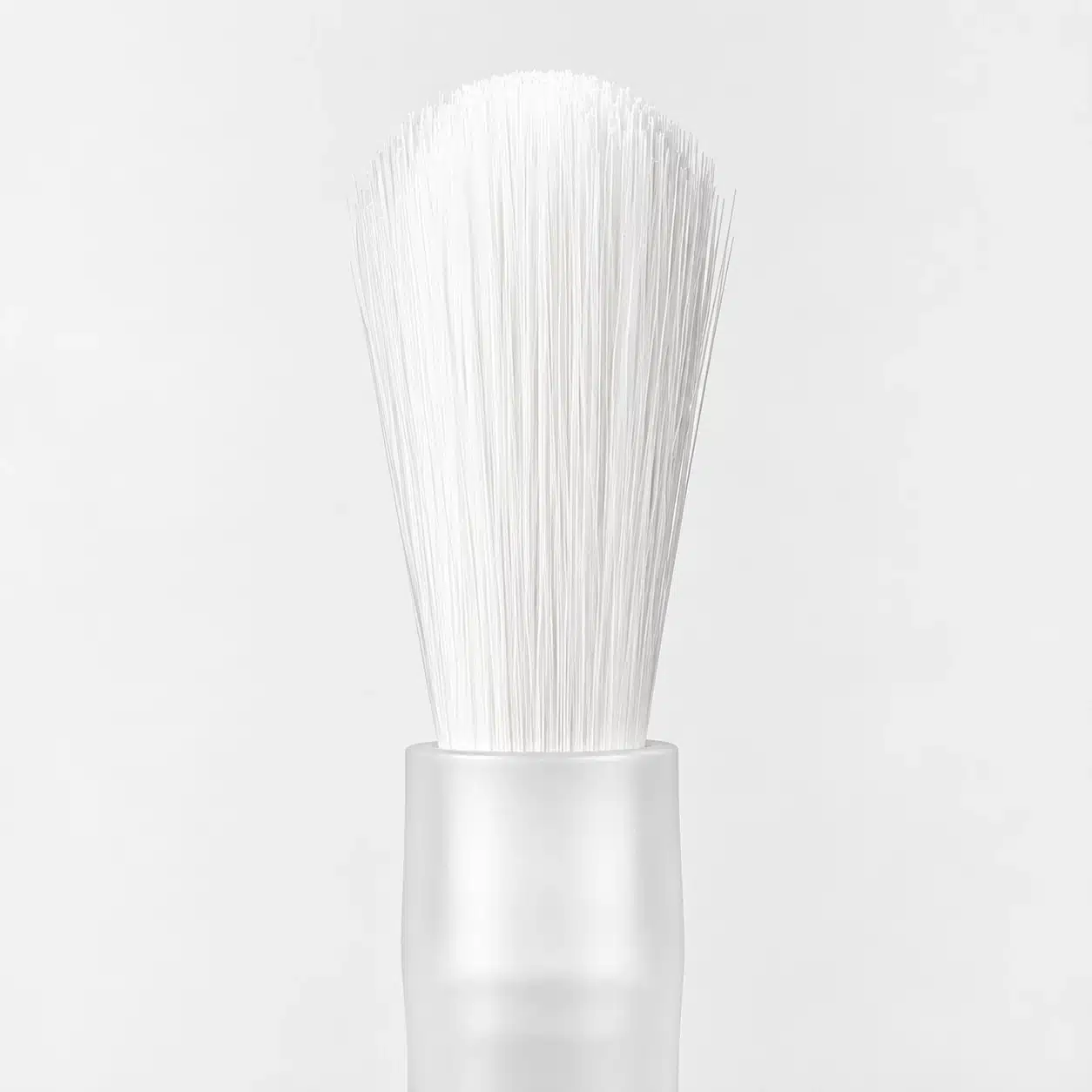 White bottle brush with a rounded bristle edge and translucent plastic stem.