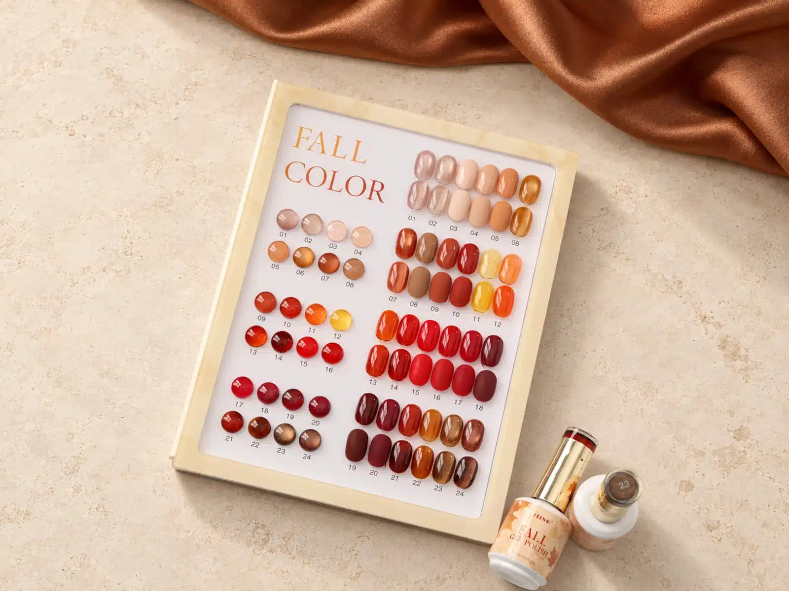 Numbered JTING 24-color fall gel polish chart on warm ivory stone with copper-brown satin