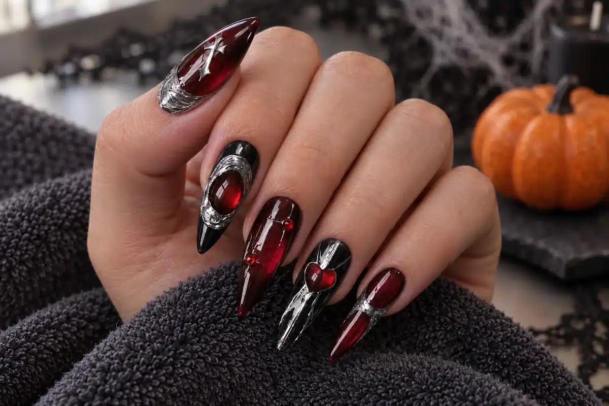 Deep red cat-eye Halloween manicure with black nails, silver sculpted details and small red gel beads